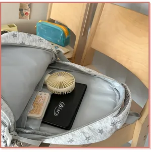 Interior detail of a grey school backpack with white star patterns showing storage capacity