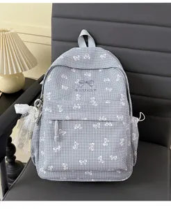 Détail du sac à dos à carreaux gris avec motifs de nœuds et décoration en dentelle