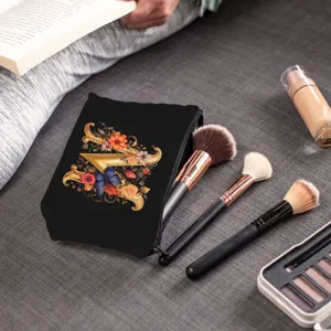 Primo piano di borsa trucco nera con lettera Z floreale e pennelli professionali