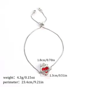 Silver adjustable bracelet with red cubic zirconia sacred heart pendant and crown detail.