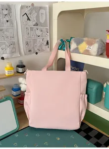 Close-up of a pink Japanese style student tote bag on a stationery-themed desk