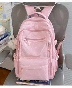 Sac à dos rose mignon avec motifs d'étoiles et pendentif lapin en peluche sur une chaise