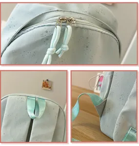Detalles de mochila verde menta con estrellas, mostrando cremalleras y costuras de asas