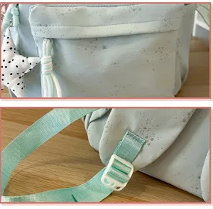 Primer plano de mochila verde menta con patrón de estrellas plateadas y correa ajustable