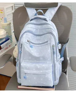 Vue détaillée d'un sac à dos scolaire bleu clair à étoiles sur une chaise de bureau