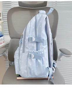 Vue latérale d'un sac à dos scolaire bleu clair avec des motifs d'étoiles blanches