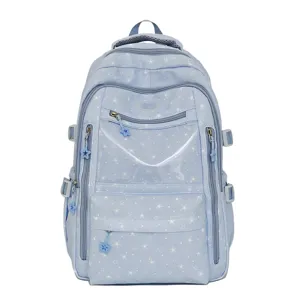 Détail d'un sac à dos scolaire bleu clair avec motifs étoiles et poche transparente
