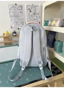 Vista posteriore dettagliata dello zaino da studente in nylon azzurro con manico rosa