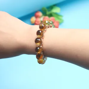 Close-up detail of a colorful faceted crystal bead bracelet worn on wrist with metal links.