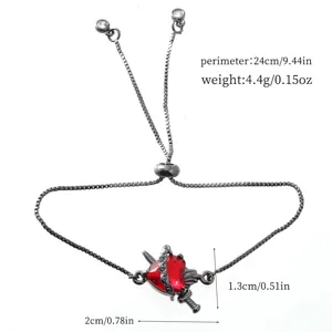 Detail shot of black adjustable box chain bracelet featuring a red heart and dagger charm, 24cm.