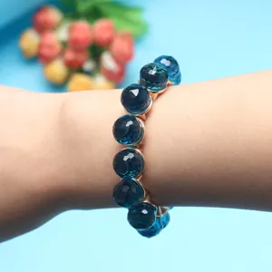 Close-up of blue faceted crystal bead bracelet detail showcasing shimmering surface and elastic band.