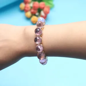Close-up detail shot of faceted pink crystal bead stretch bracelet worn on the wrist elegantly.