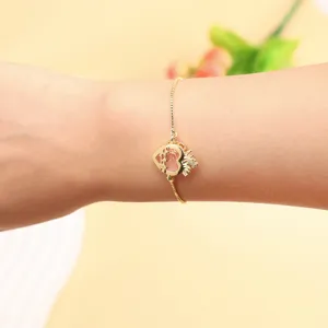 Detail shot of gold adjustable bracelet with crown heart pink zircon, elegant wristwear style.