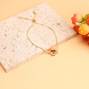 Close-up detail of the red zircon heart pendant bracelet with golden adjustable chain.