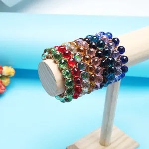 Close-up detail of multi-layer colorful faceted crystal bead stretch bracelet on wooden stand.