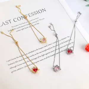Adjustable heart zircon bracelet detail showing gold and silver chains with red and pink stones.
