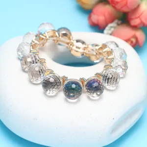 Detailed shot of a colorful faceted crystal bead bracelet with gold tone connectors and elastic cord.
