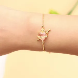 Elegant gold-tone bracelet featuring a pink heart zircon with dagger and rose design details.