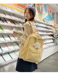 Mochila amarilla con lunares de corazones usada en una tienda de papelería muy moderna