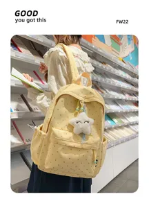 Mochila amarilla de lunares con colgante de estrella llevada por una estudiante