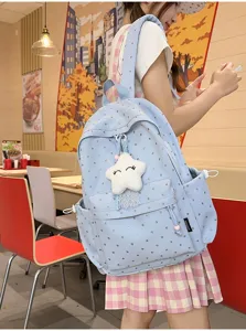 Vista detallada de mochila escolar azul claro con diseño de corazones y amuleto de estrella