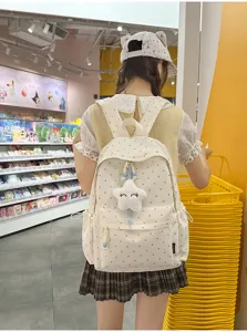 Vista trasera de una niña con una mochila blanca con estampado de corazones en una tienda