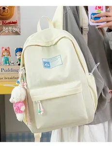 Dettaglio dello zaino scolastico crema con ciondolo a forma di orsetto e logo minimal