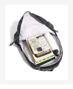 Internal view of camouflage backpack showing large capacity with books and water bottle