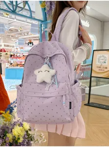 Detalle de mochila morada con lunares y colgante de estrella de peluche en modelo