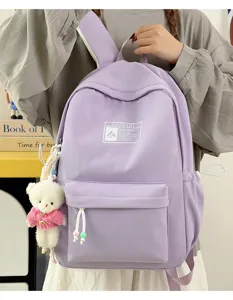 Dettaglio di uno zaino scolastico color lavanda con un simpatico ciondolo a forma di orso