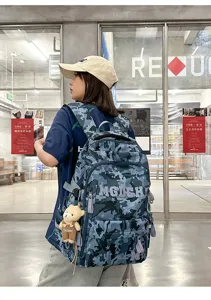 Young woman wearing a cool camouflage schoolbag with star patterns and a bear charm.