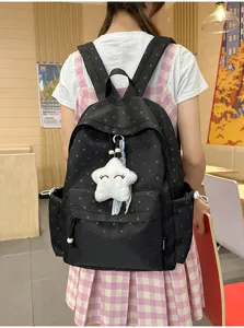 Mochila escolar negra con lunares y un lindo colgante de peluche de estrella blanca