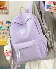 Vista dettagliata di uno zainetto scolastico viola con portachiavi a forma di orso