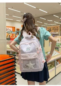 Mochila japonesa de rayas con estrellas y bolsillo transparente llevada por modelo