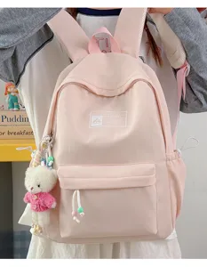 Vista dettagliata di uno zaino scolastico rosa con un simpatico orsetto bianco appeso