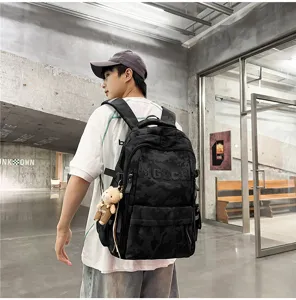 Detailed back view of a cool camo graffiti backpack worn by a male model in a hall