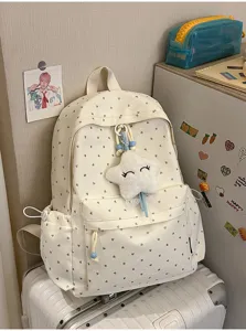 Vista detallada de la mochila blanco crema con estampado de corazones y estrella
