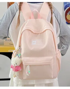 Vista posteriore di uno zaino scolastico rosa in stile coreano con un simpatico ciondolo a orso