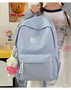 Dettaglio di uno zaino per studenti azzurro con un simpatico orsetto di peluche