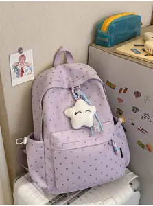 Mochila escolar violeta con patrones de corazones y colgante de estrella en una habitación
