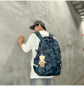 Back view of a stylish blue camouflage backpack featuring a cute bear keychain accessory