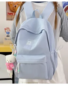Dettaglio dello zaino scolastico azzurro minimalista con un grazioso ciondolo a forma di orsetto