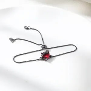Detailed shot of a black adjustable chain bracelet featuring a sparkling red heart zircon stone.
