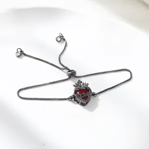 Detailed view of the red zircon heart slider bracelet with black metal chain and crown.