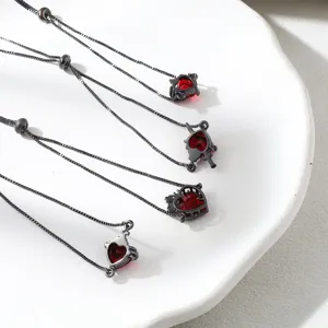 Close-up detail view of black chain bracelet featuring red zircon heart shaped pendants.