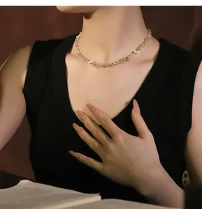 Detailed macro shot of a handcrafted natural pearl and prehnite stone necklace on model