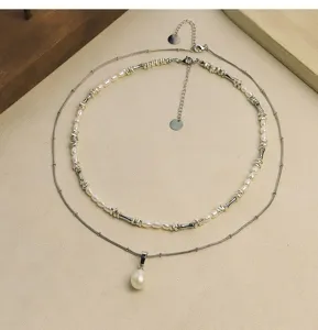Detailed macro view of elegant layered bamboo joint necklace with natural pearls.