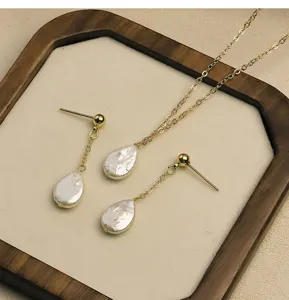 Vista detallada del conjunto de collar y pendientes de perlas barrocas naturales en oro