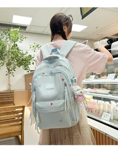 Detail eines hellblauen Schülerrucksacks mit bunten Punkten und einem Hundestofftier