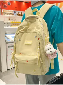 Detailansicht eines gelben Schülerrucksacks mit bunten Punkten und süßem Hundeanfänger